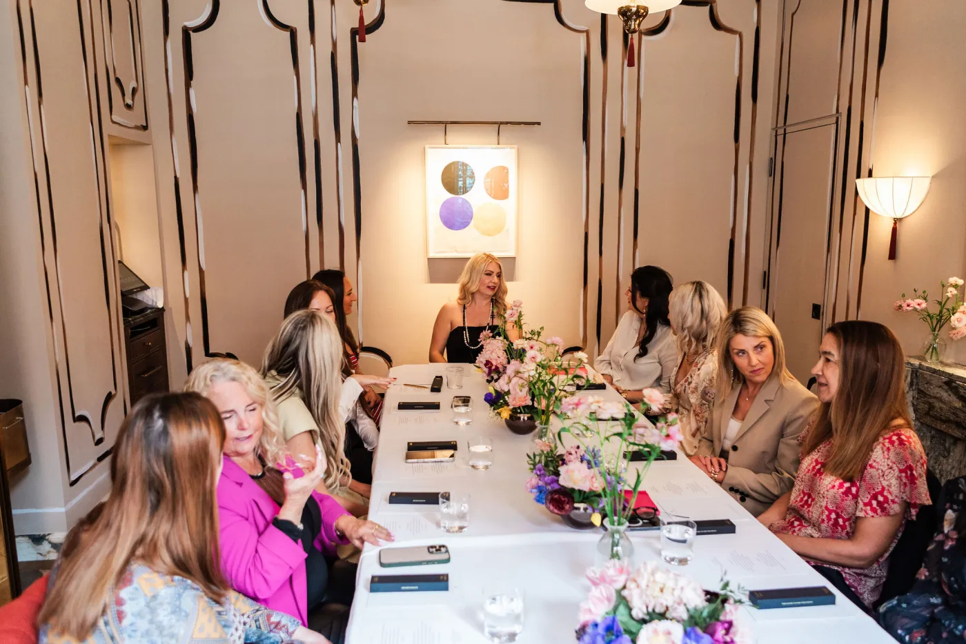 Emily Williams hosting guests around a flower-filled lunch table in London