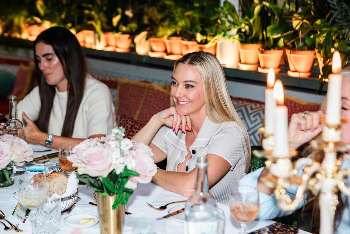 Emily Williams seated at a London event table with flowers and candles
